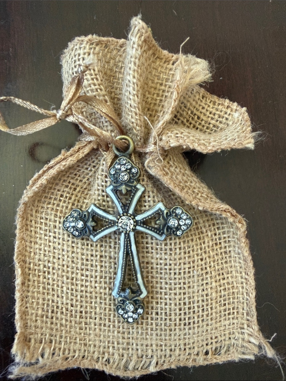 Antique cross with rhinestone in burlap bag